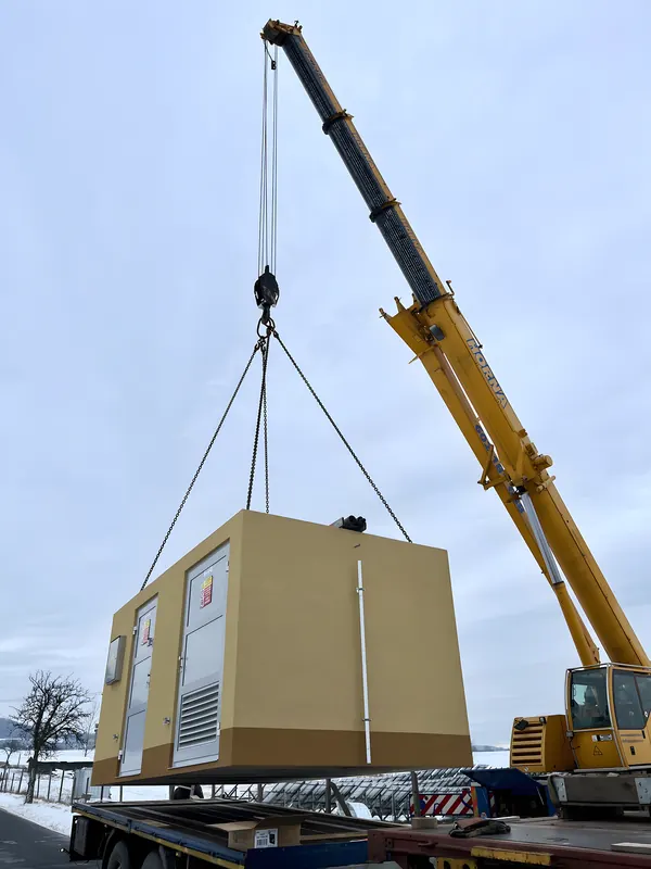 Jeřáb usazuje kompaktní trafostanici pro fotovoltaickou elektrárnu v&nbsp;Žalanech